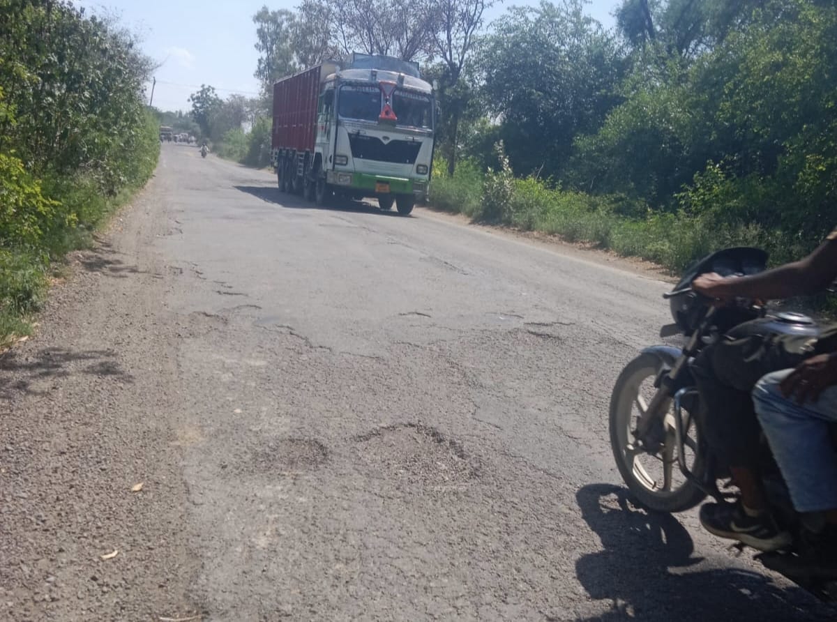 जर्जर हो चुके चीका रोड से गुजरती स्कूटी सवार महिला।