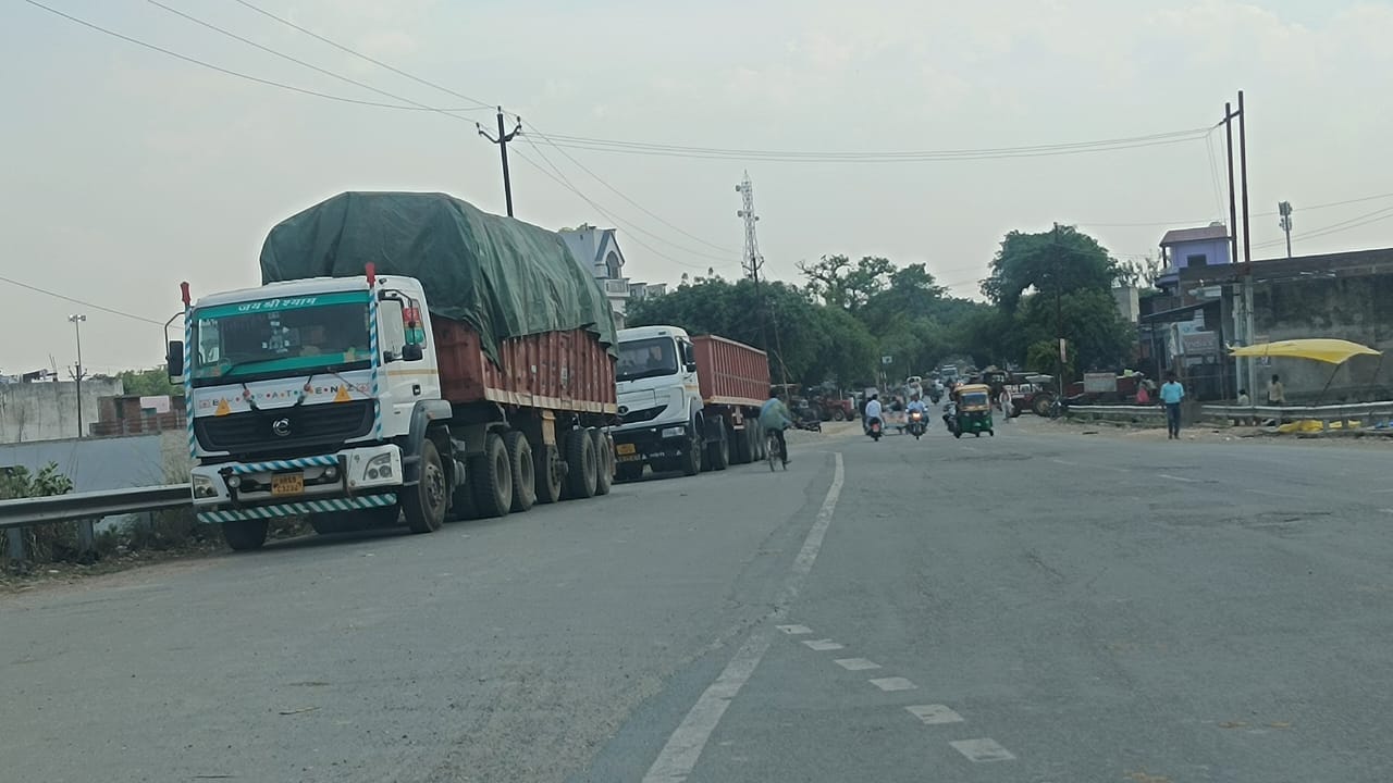 लखनऊ-दिल्ली नेशनल हाईवे पर रोजा क्षेत्र में सड़क पर खड़े ट्रक। संवाद