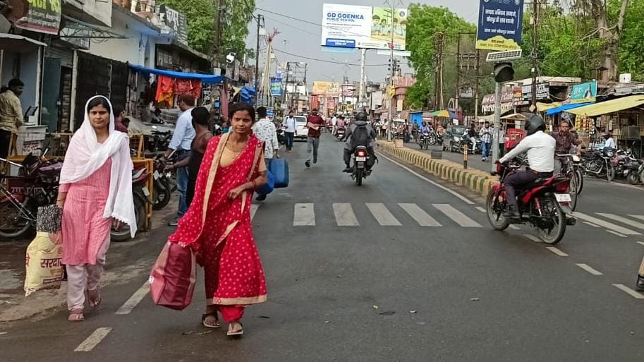 मंगलवार दोपहर बारिश होने पर शहर में भीगते हुए जाते लोग। संवाद