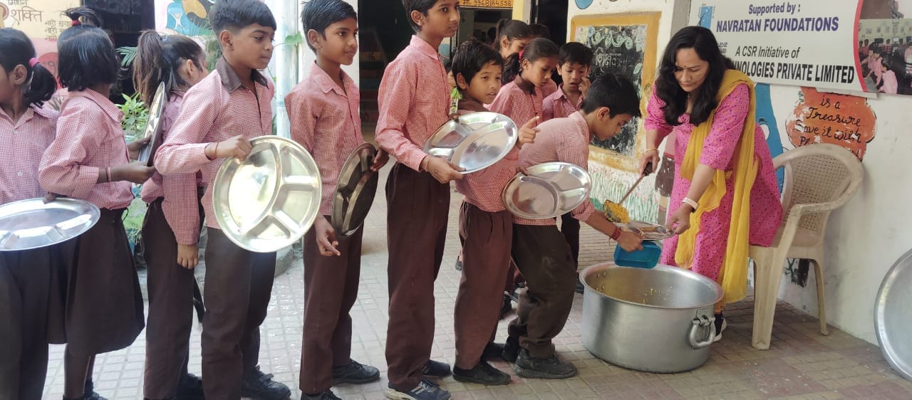 नोएडा। सेक्टर 104 स्थित प्राथमिक विघालय में मिड्डे मील लेते बच्चे । संवाद