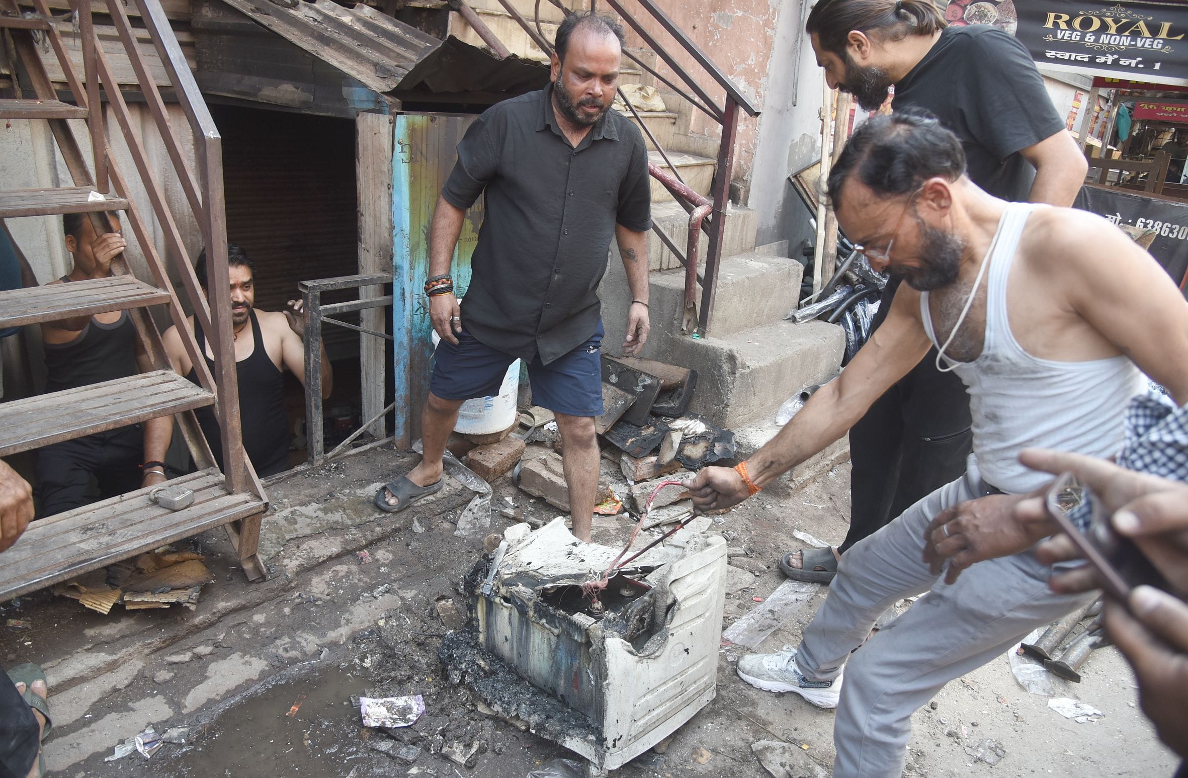 नाका स्थित दुकान में लगी आग बुझाते दमकल कर्मी व मौजूद भीड़।