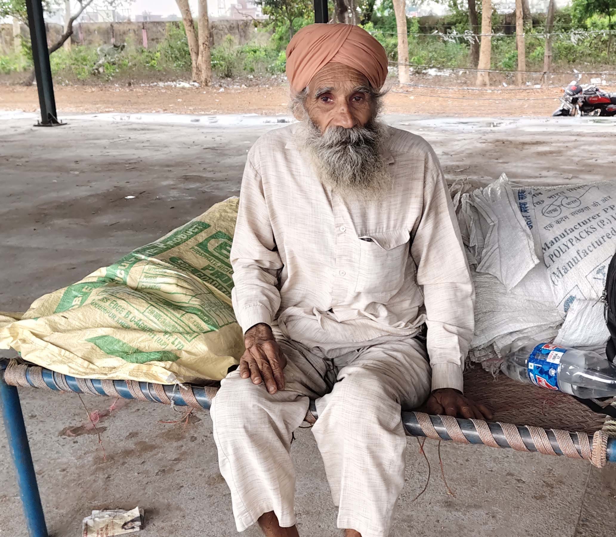 गेहूं लेकर पुवायां मंडी में जमीन पर बिस्तर लगाकर लेटे गांव जेबां के किसान राजन। संवाद गेहूं लेकर पुवायां मंडी में जमीन पर बिस्तर लगाकर लेटे गांव जेबां के किसान राजन। संवाद