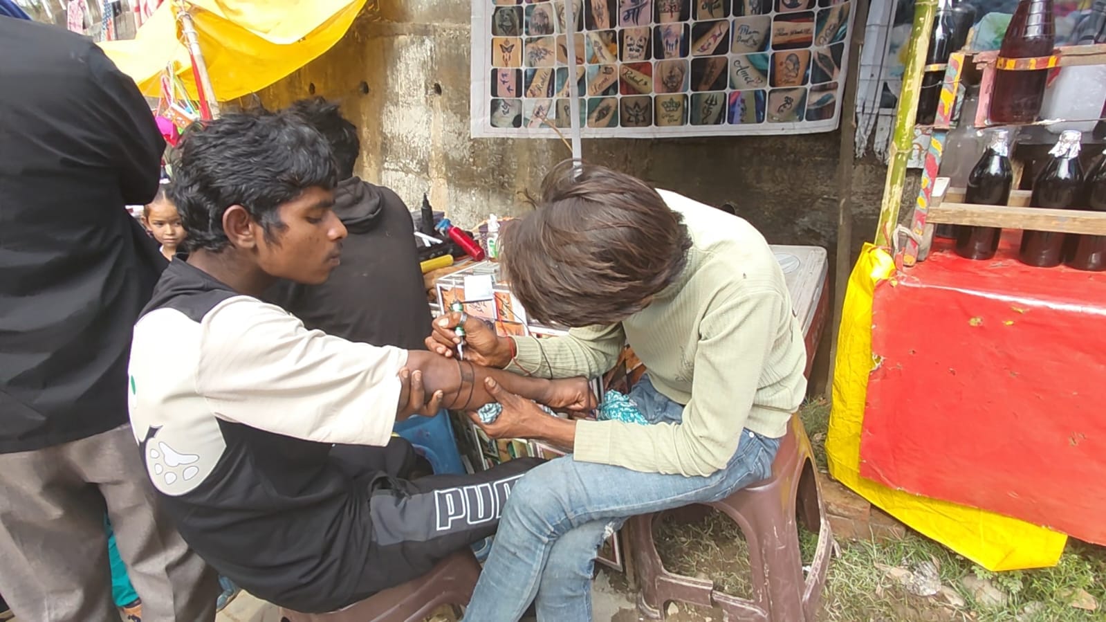 घुमारवीं में आयोजित ग्रीष्मोत्सव में टैटू बनाते लोग। संवाद