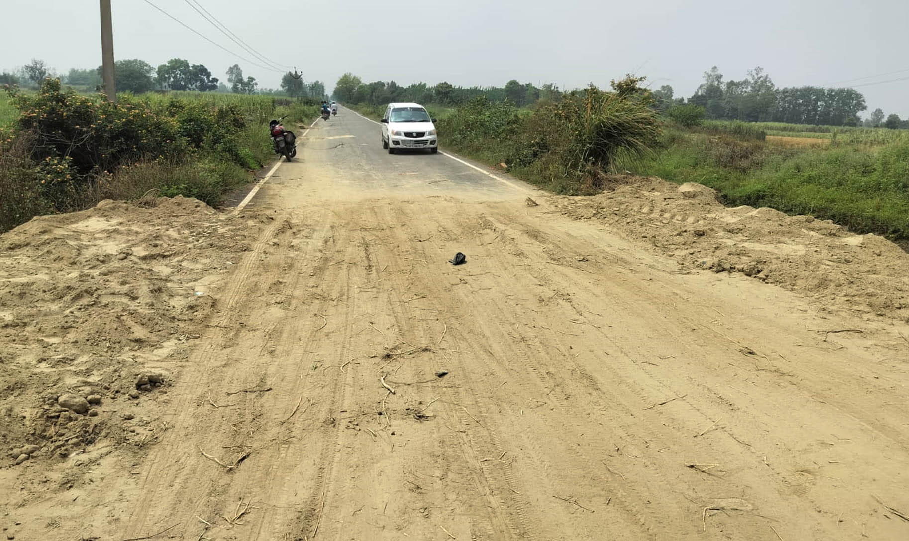 क्षतिग्रस्त पटरी को ठीक करती जेसीबी मशीन: ग्रामीण