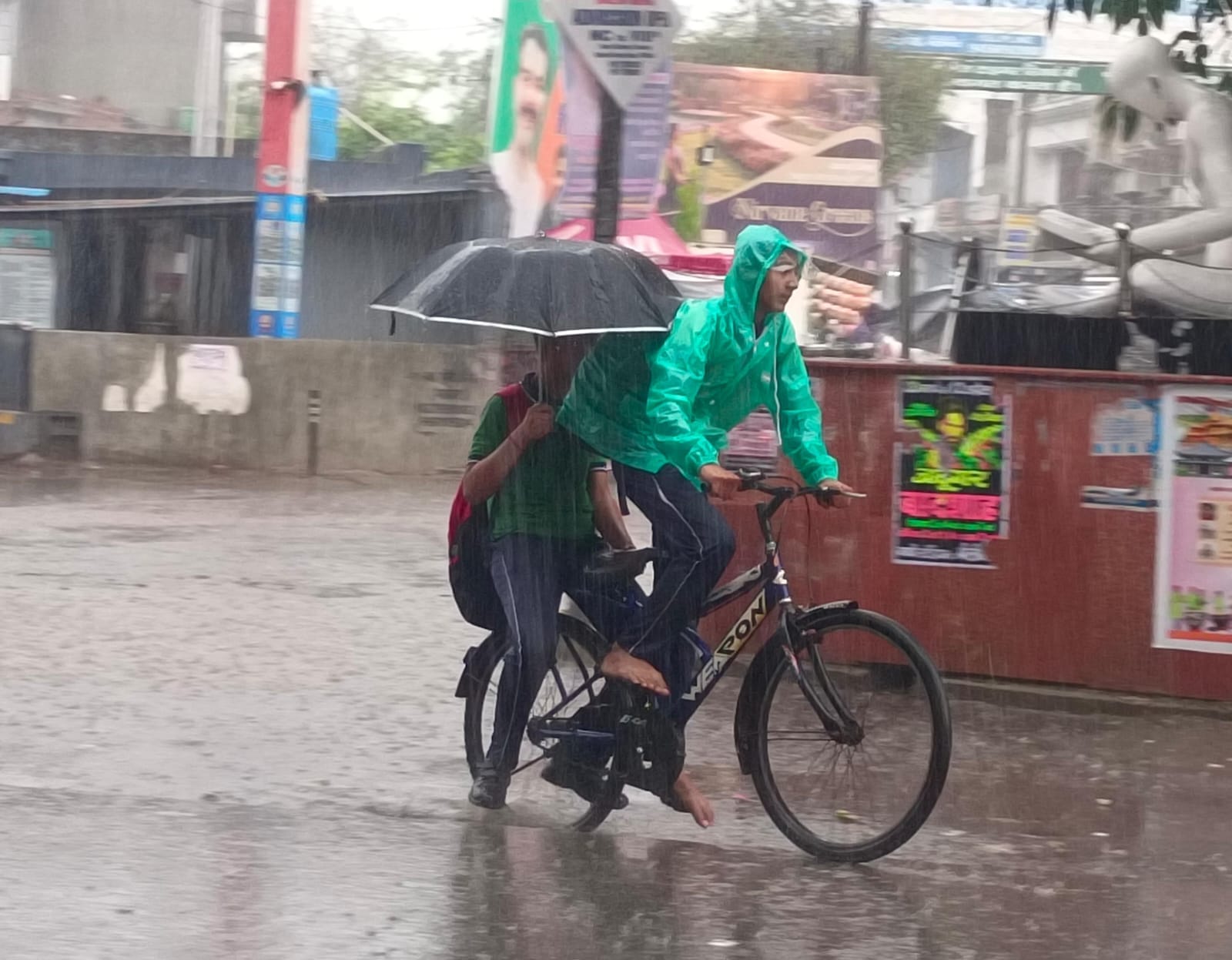 स्टेशन मार्ग पर भरे तालाब जैसे पानी से गुजरते राहगीर। संवाद