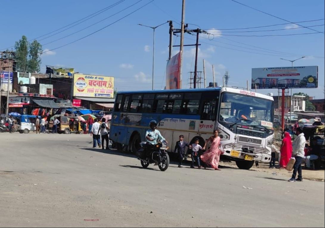 शहर के बरेली मार्ग पर टेंपों पर लटक कर जाते यात्री। संवाद