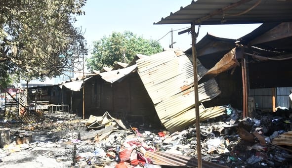 आग बुझने के बाद सामान ढूंढते लोग।