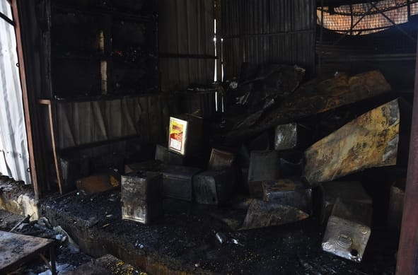 आग बुझने के बाद सामान ढूंढते लोग।