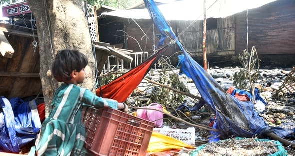 आग बुझने के बाद सामान ढूंढते लोग।