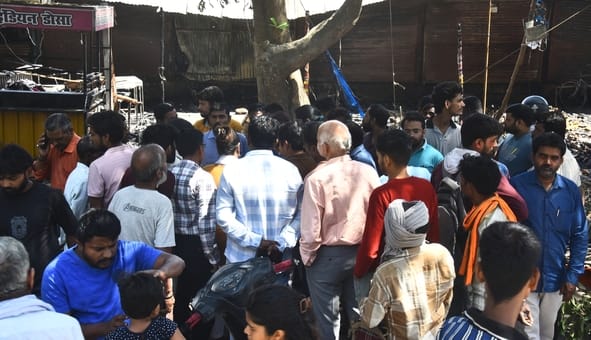 आग बुझने के बाद सामान ढूंढते लोग।