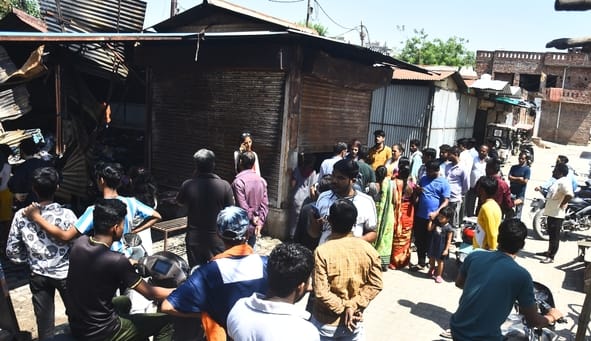 आग बुझने के बाद सामान ढूंढते लोग।