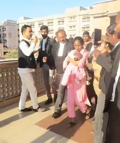 हाईकोर्ट की छत पर बच्चे के साथ चढ़ी महिला को पुलिस ने उतारा। 