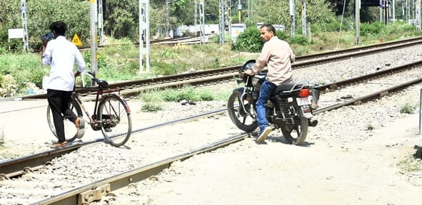 रेलवे क्रॉसिंग को पार करते लोग। रेलवे क्रॉसिंग को पार करते लोग।