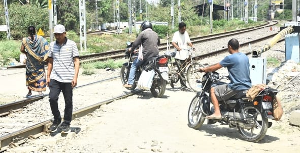 रेलवे क्रॉसिंग को पार करते लोग। रेलवे क्रॉसिंग को पार करते लोग।