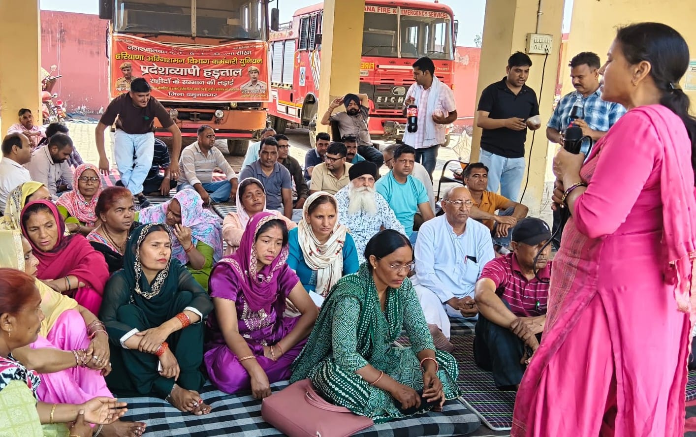 दमकल केंद्र के बाहर हड़ताल पर बैठे कर्मचारियों को संबोधित करतीं वक्ता।संवाद दमकल केंद्र के बाहर हड़ताल पर बैठे कर्मचारियों को संबोधित करतीं वक्ता।संवाद