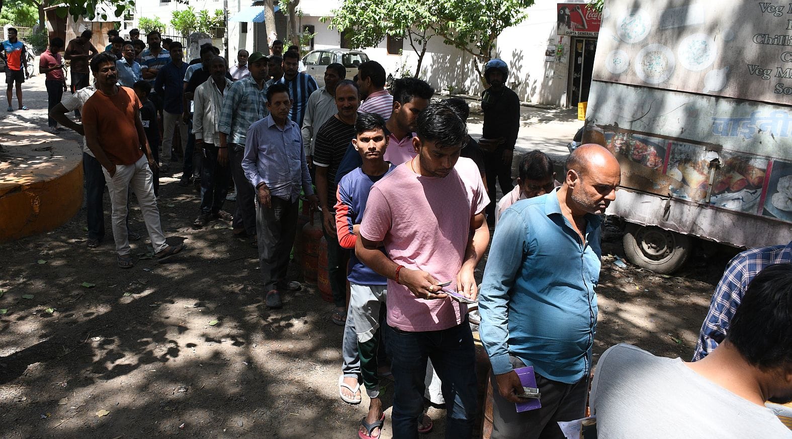 गैस सिलिंडर लेने पहुंचे लोग।