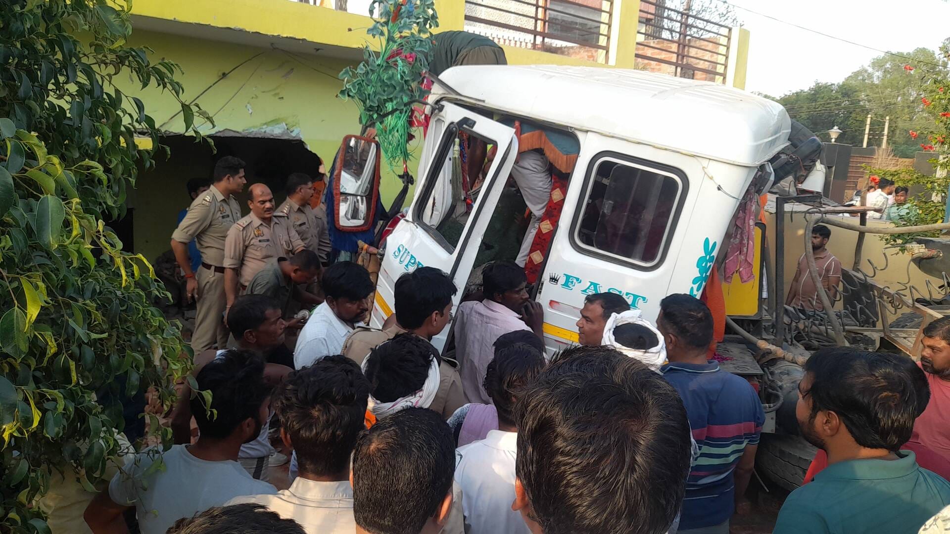 फुलवरिया बाईपास पर घर में घुसा ट्रेलर व चालक को केबिन काटकर निकालते ग्रामीण और पुलिसकर्मी।