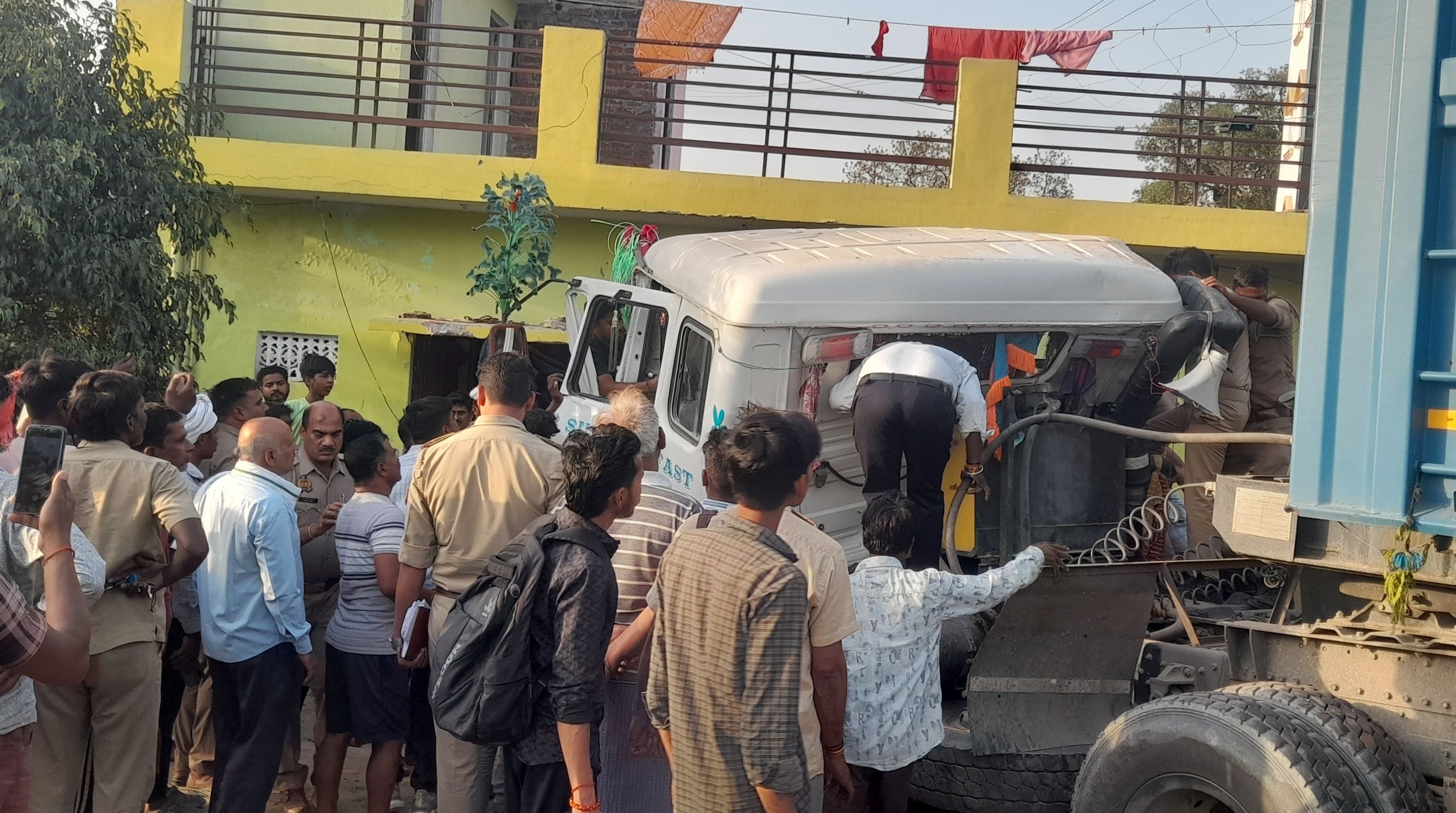 फुलवरिया बाईपास पर घर में घुसा ट्रेलर व चालक को केबिन काटकर निकालते ग्रामीण और पुलिसकर्मी।