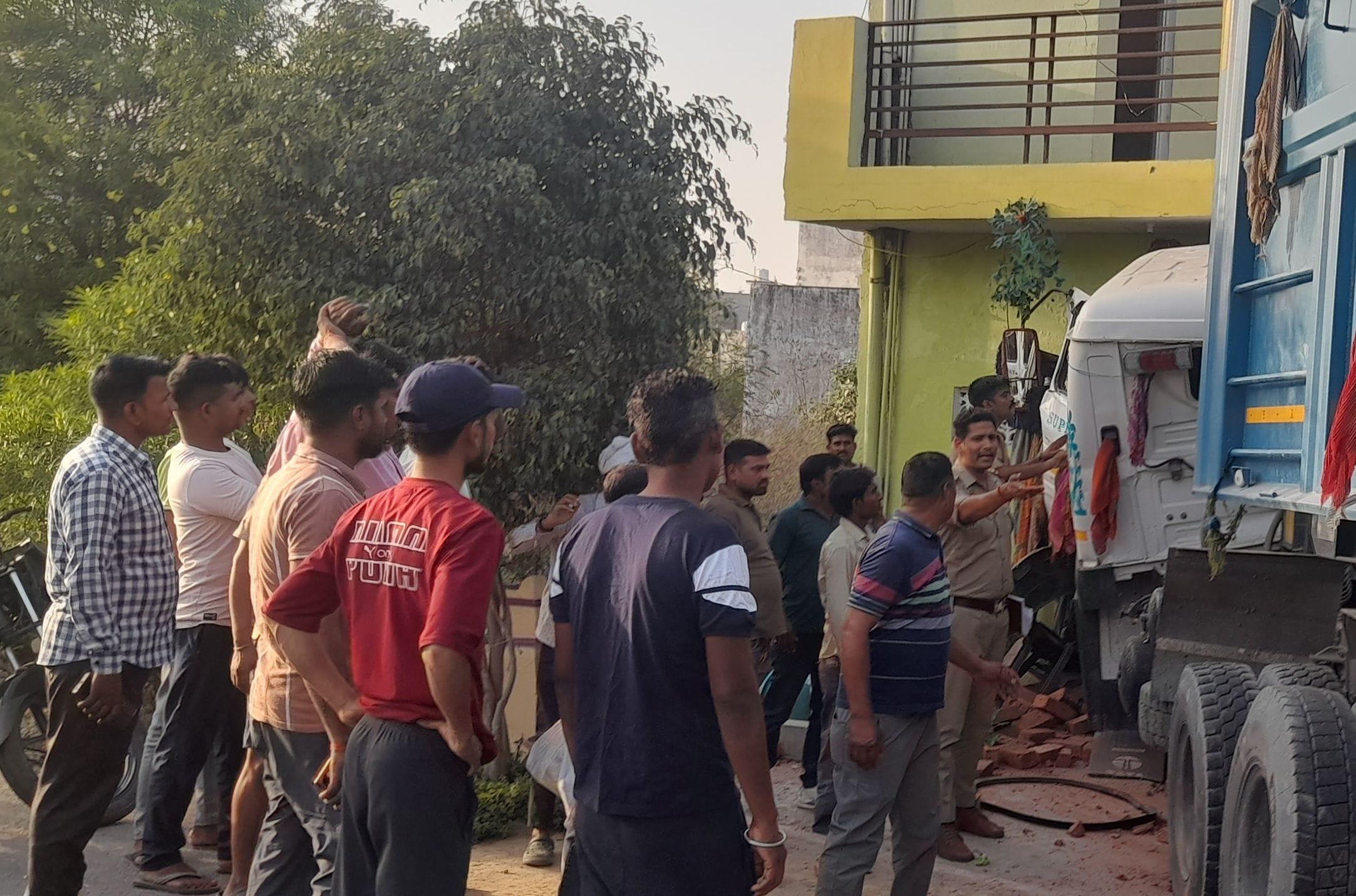 फुलवरिया बाईपास पर घर में घुसा ट्रेलर व चालक को केबिन काटकर निकालते ग्रामीण और पुलिसकर्मी।