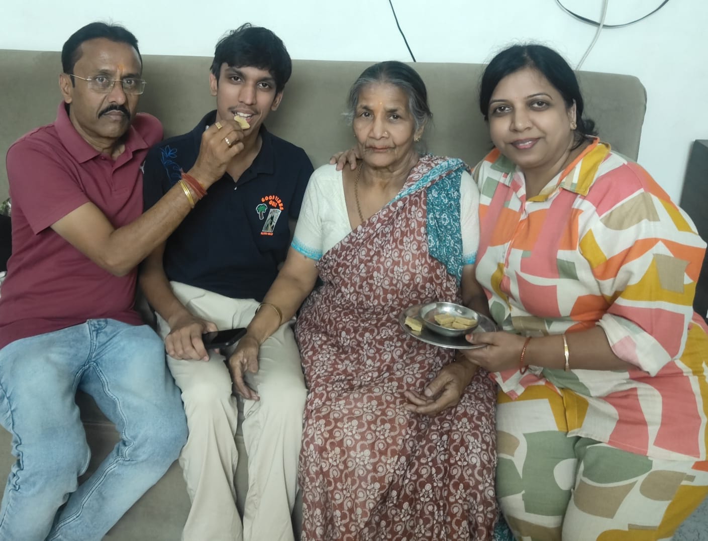 सीबीएसई की जिला टॉपर शिजा को मिठाई खिलाते परिजन। स्रोत: स्वयं