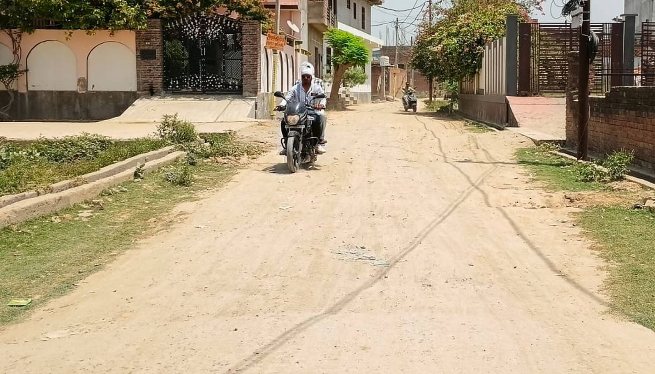 फोटो-21-शहर के शिवपुरम् कालोनी की जर्जर सड़क से निकलते बाइक सवार। संवाद