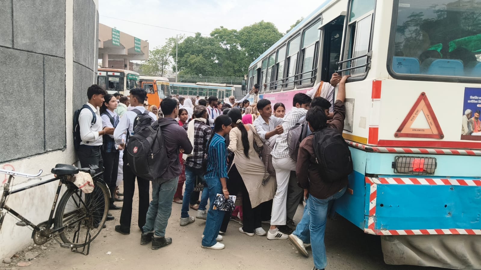 भाई कन्हैया साहिब चौक के पास भीड़ होने से बस के पायदान पर सवार होकर जाते विद्यार्थी। संवाद भाई कन्हैया साहिब चौक के पास भीड़ होने से बस के पायदान पर सवार होकर जाते विद्यार्थी। संवाद