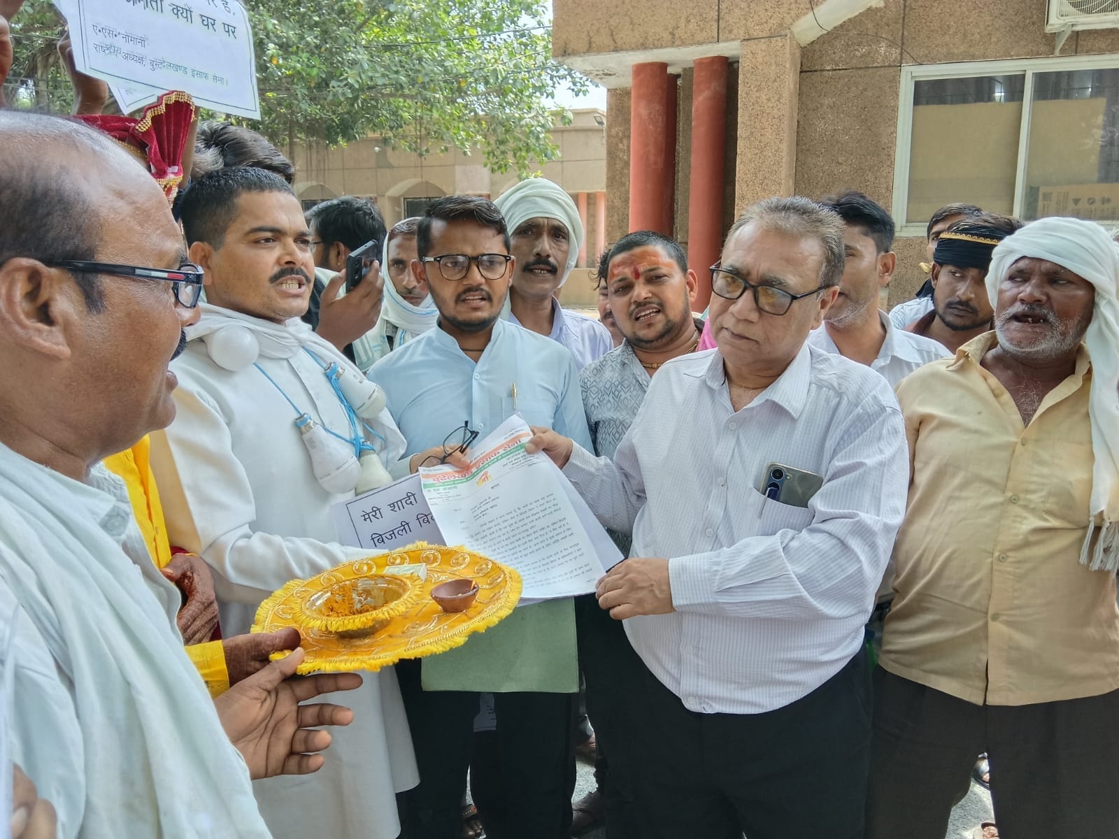 फोटो - 19 बिजली पोल की आरती उतारता दूल्हा व बुंदेलखंड इंसाफ सेना के पदाधिकारी, महिलाएं। संवाद