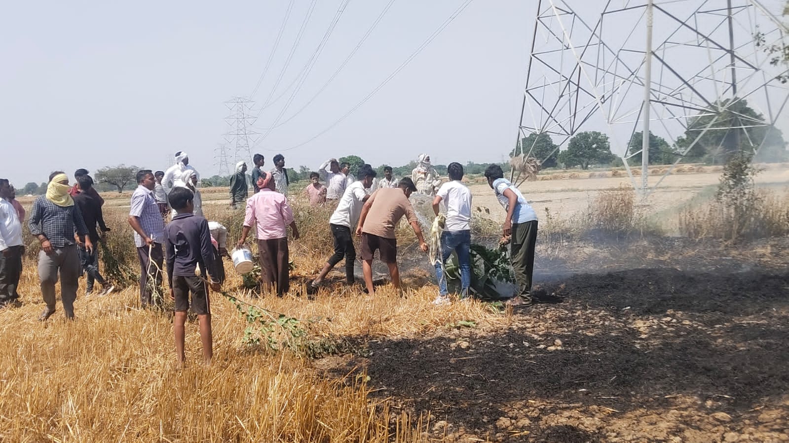 फोटो-26-खेतों में गेहूं की फसल और अवशेष में आग लगने के दौरान दूर तक बस धुआं ही नजर आता रहा । सं