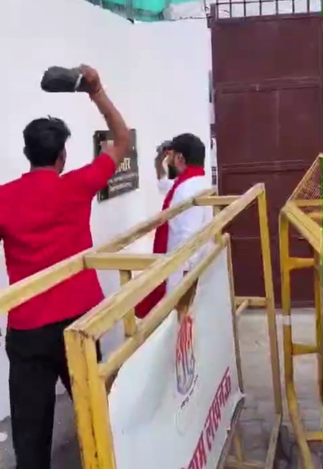 नेम प्लेट पर चप्पल मारते सपाई। नेम प्लेट पर चप्पल मारते सपाई।