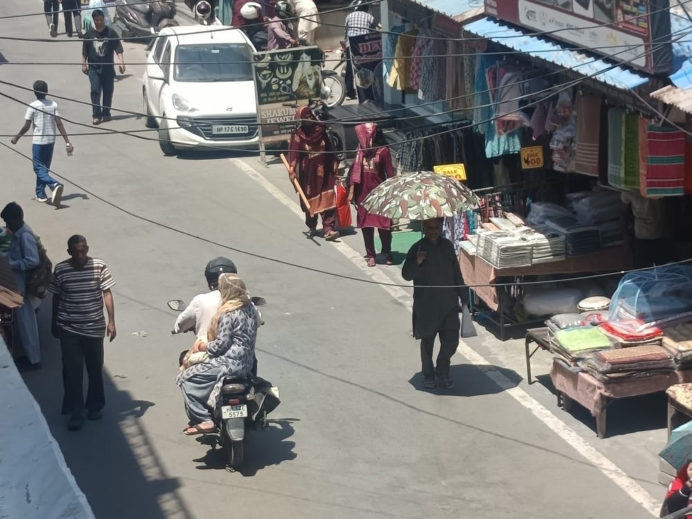पांवटा साहिब  बाजार में बढ़ती गर्मी के चलते  धूप  से बचने को छाता लेकर चलते लोग। संवाद