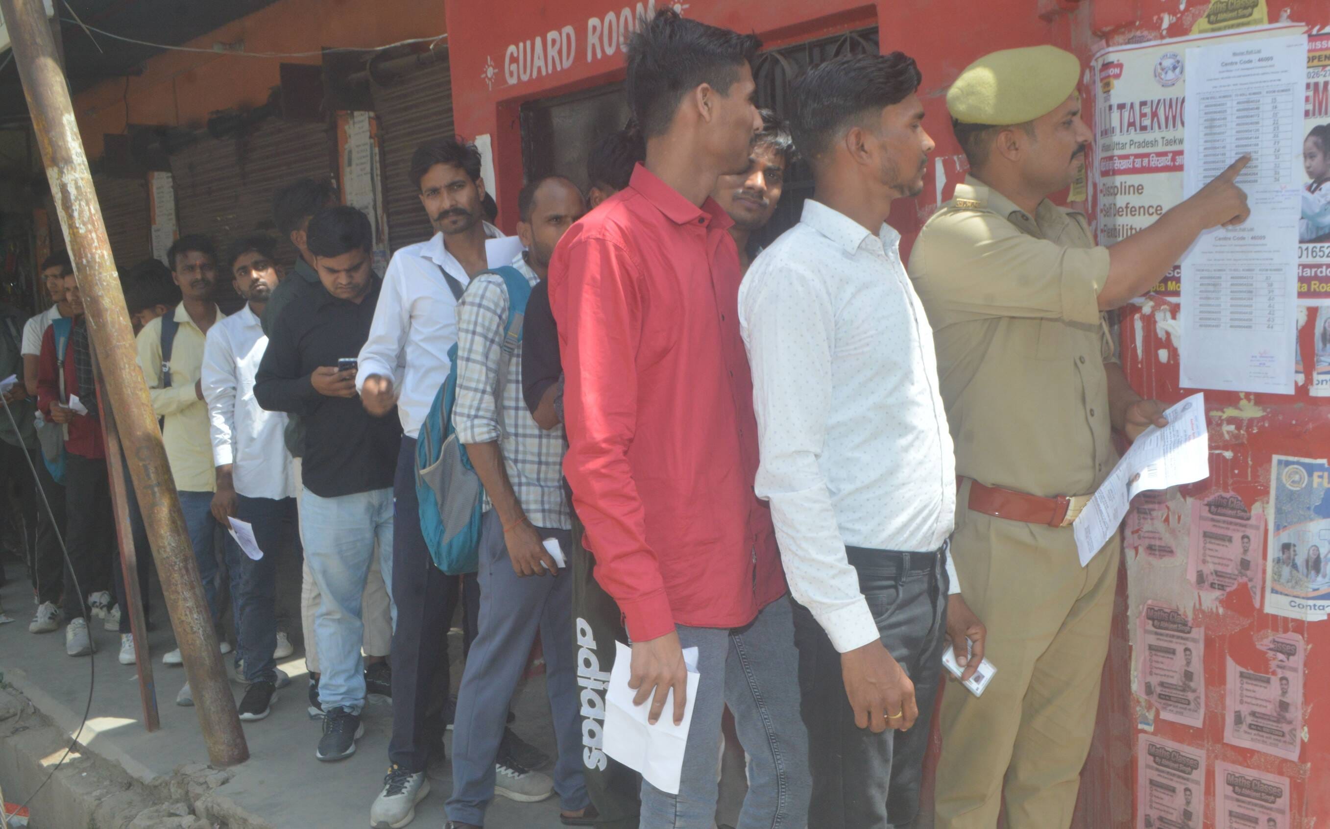 फोटो-13- होमगार्ड भर्ती परीक्षा केंद्र के बाहर महिला अभ्यार्थी की चूड़ियां उतरवाती पुलिसकर्मी। 