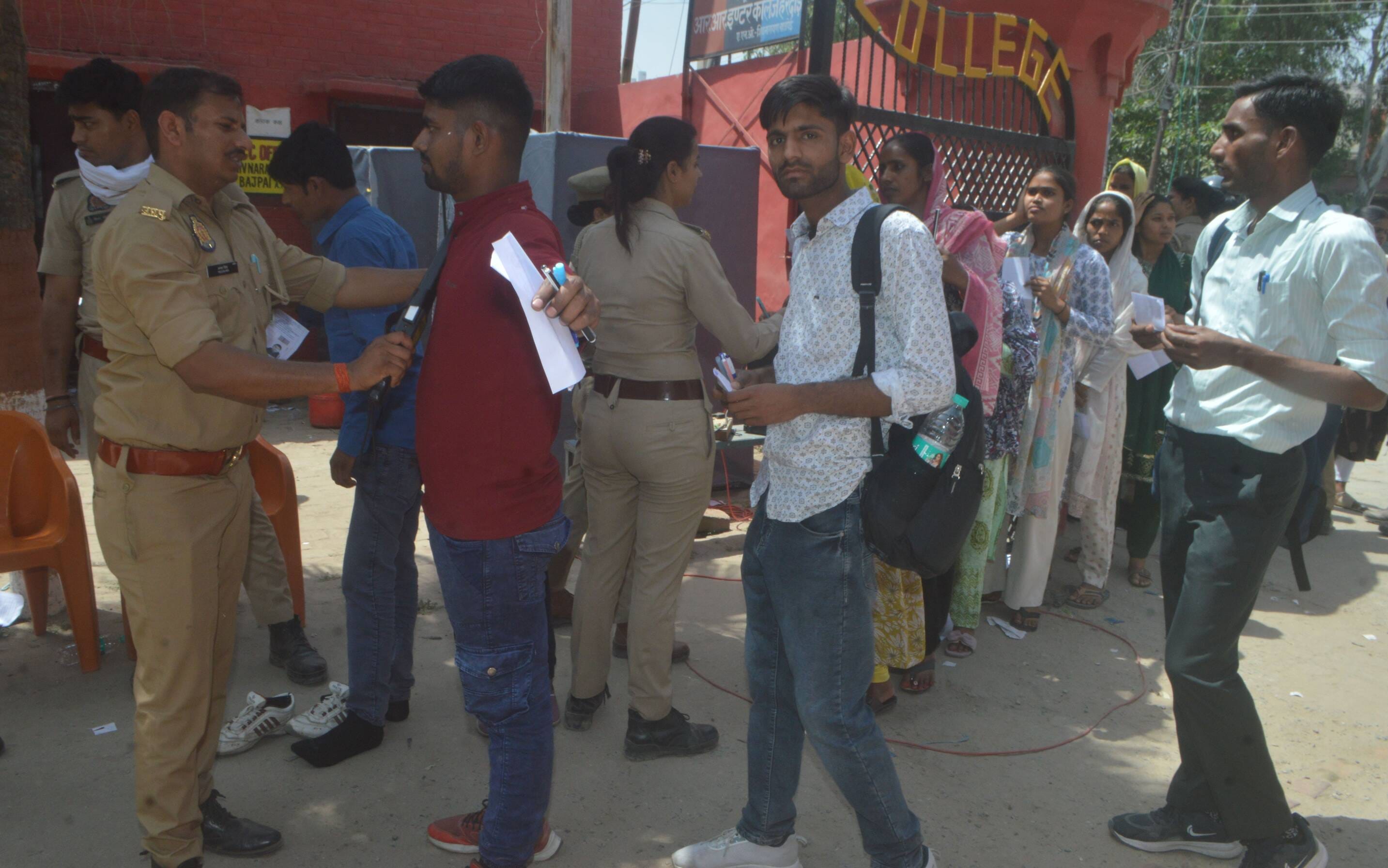 फोटो-13- होमगार्ड भर्ती परीक्षा केंद्र के बाहर महिला अभ्यार्थी की चूड़ियां उतरवाती पुलिसकर्मी। 