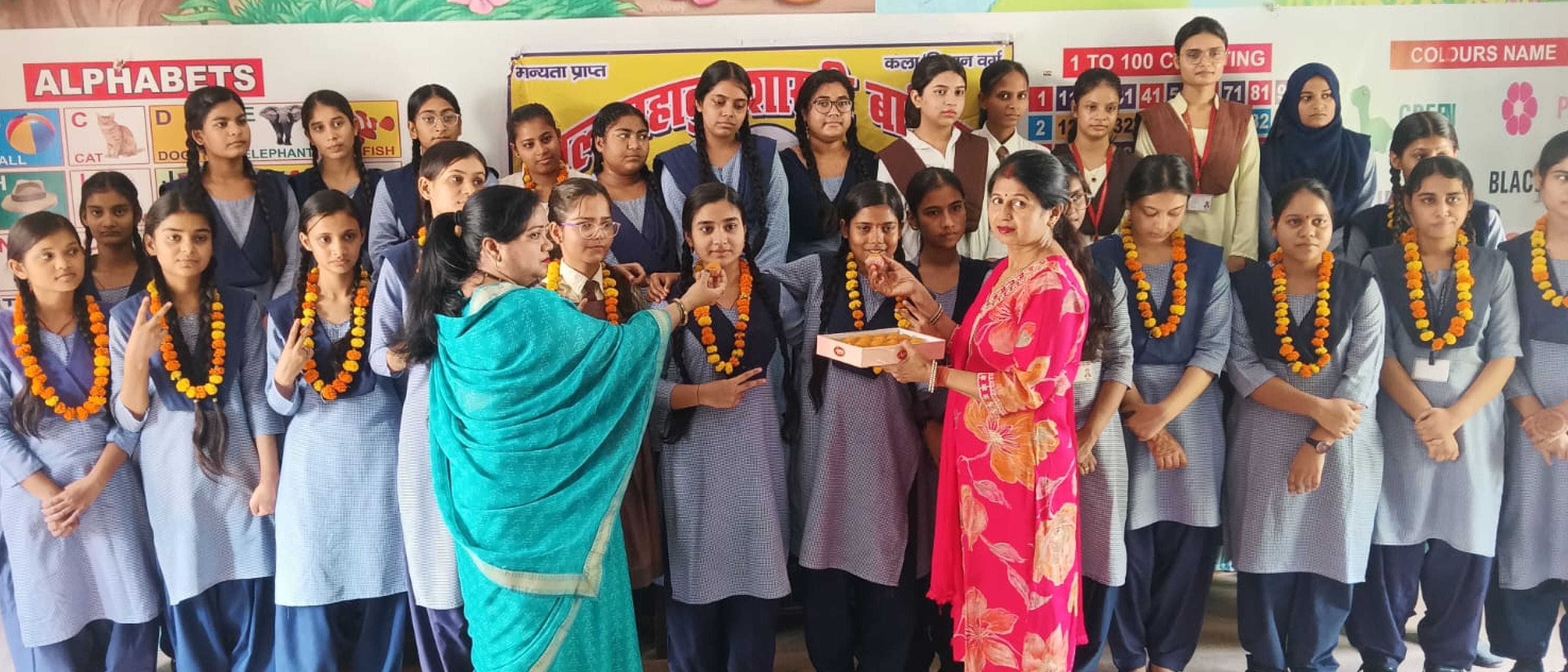 फोटो-47-शहर के लाल बहादुर शास्त्री इंटर कालेज में मेधावियों को मिठाई खिलाती अध्यापिका। संवाद