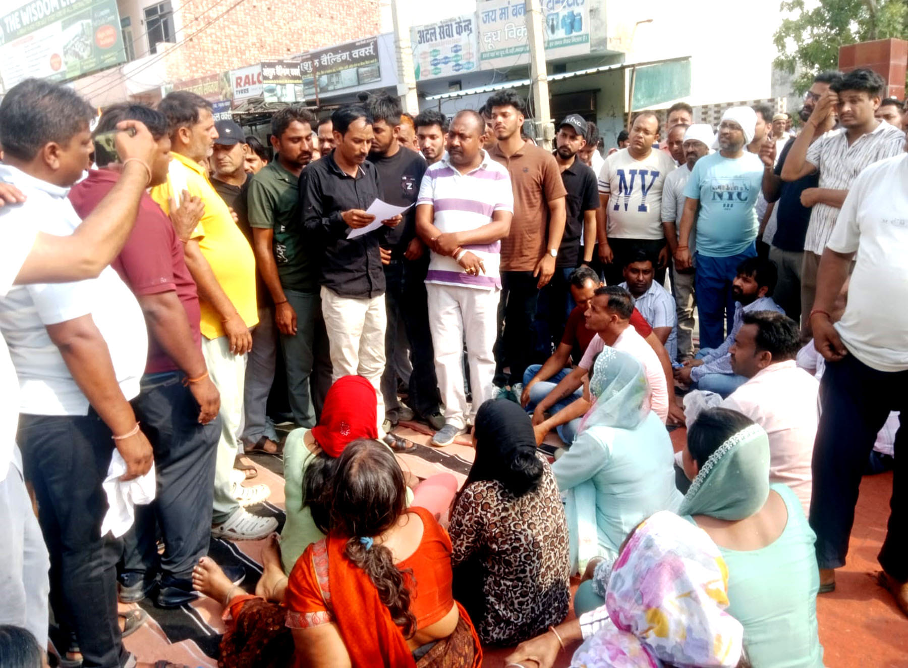 कलायत में पुलिस स्टेशन के समक्ष जमीन पर बैठकर प्रदर्शनकारियों को समझाते डीएसपी रोहताश कुमार