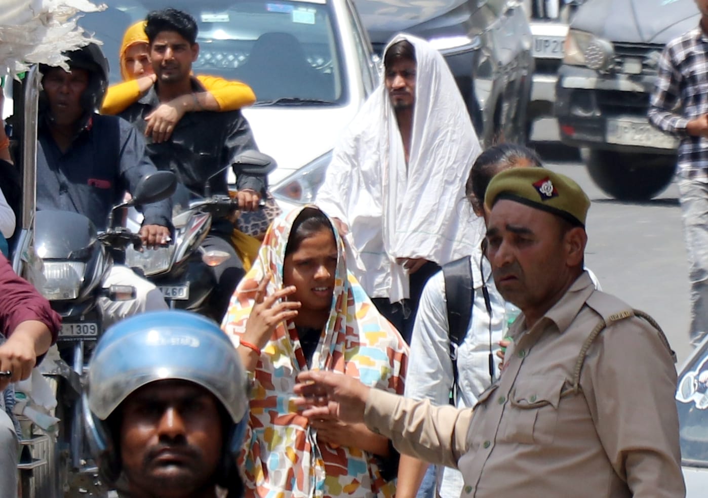 बिजनौर में भीषण गर्मी में मुंह पर दुपट्टा बांधकर जाती युवती। संवाद