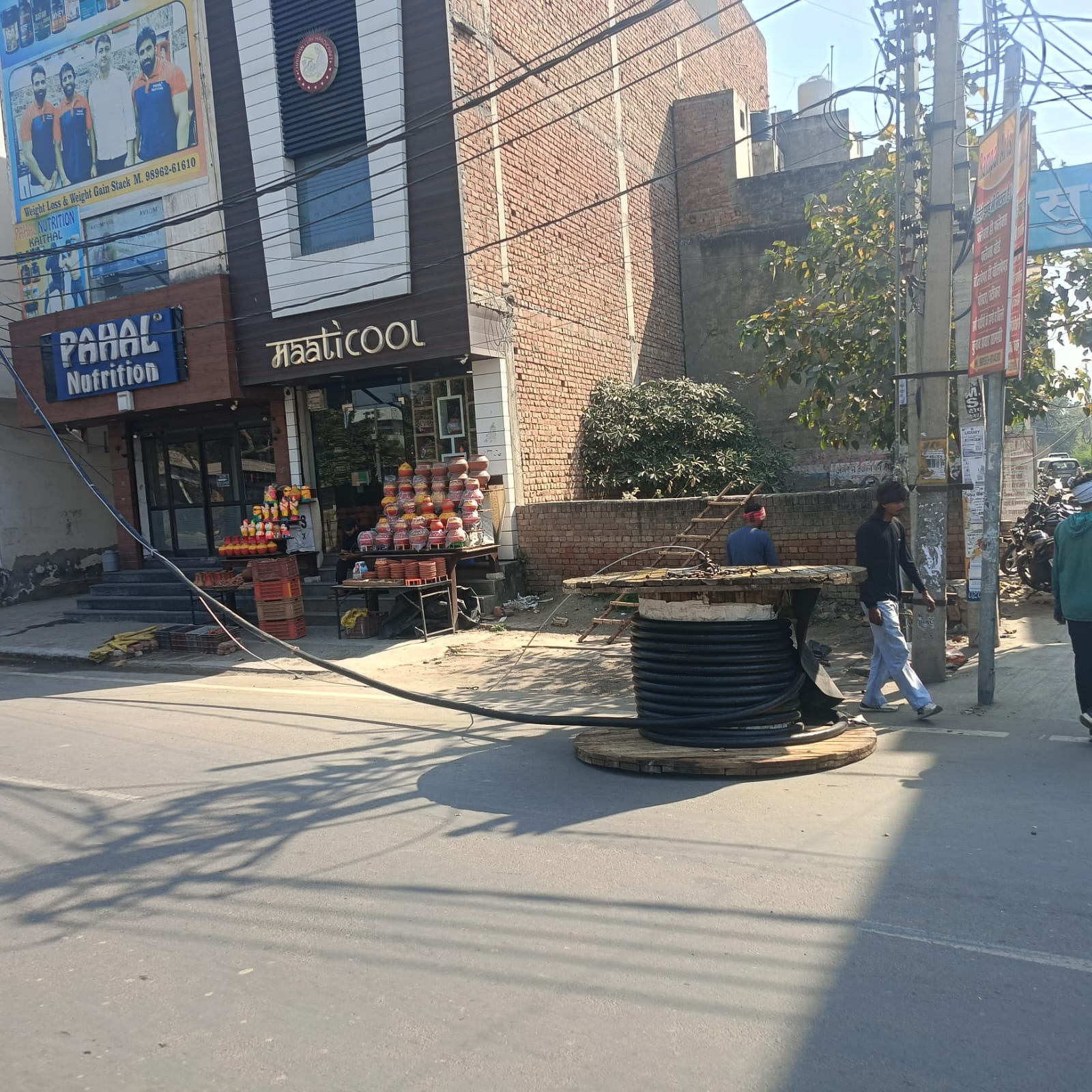 कैथल करनाल रोड पर बिजली की नई लाइन डालते कर्मचारी।