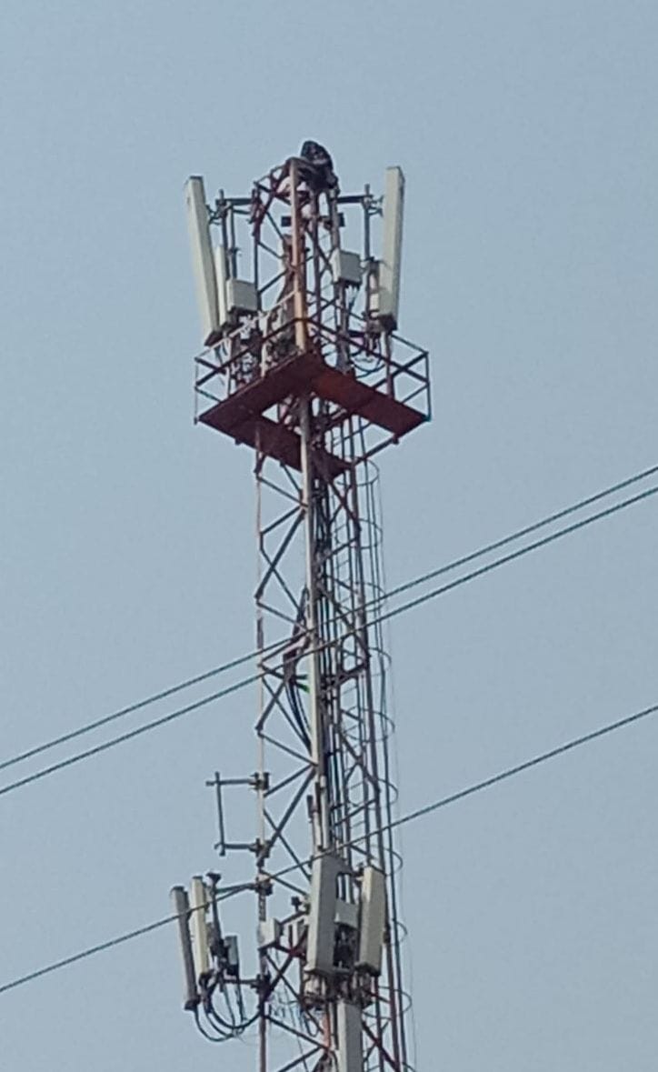 टावर पर चढ़ी महिला को देखते लोग। संवाद टावर पर चढ़ी महिला को देखते लोग। संवाद