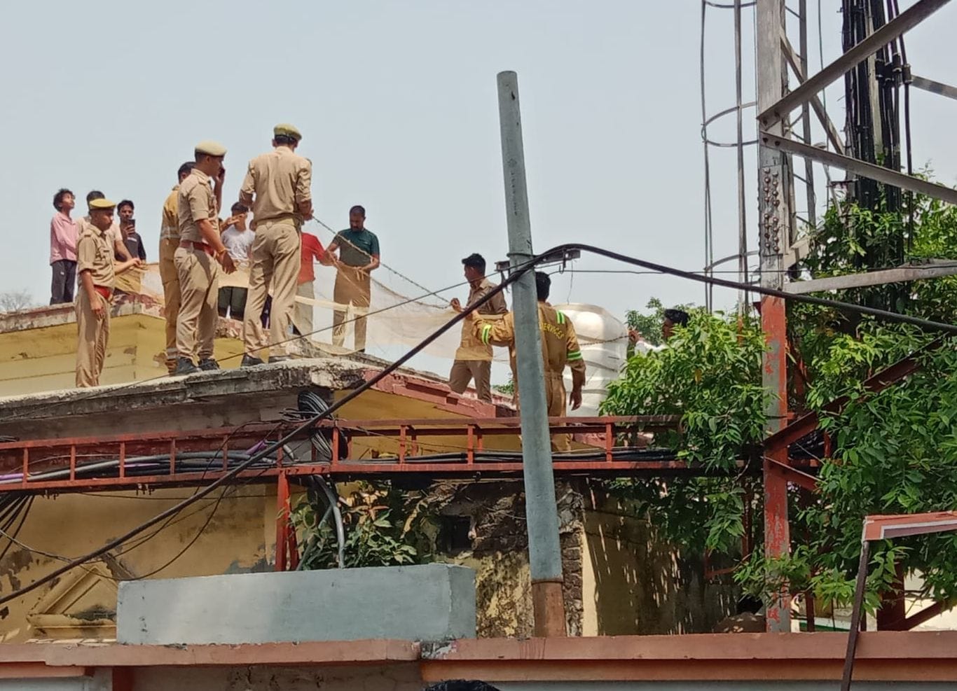 टावर पर चढ़ी महिला को देखते लोग। संवाद टावर पर चढ़ी महिला को देखते लोग। संवाद