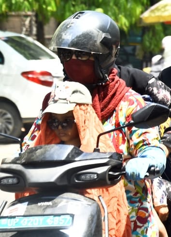 मंगलवार को धूप से बचाव करते लोग। 