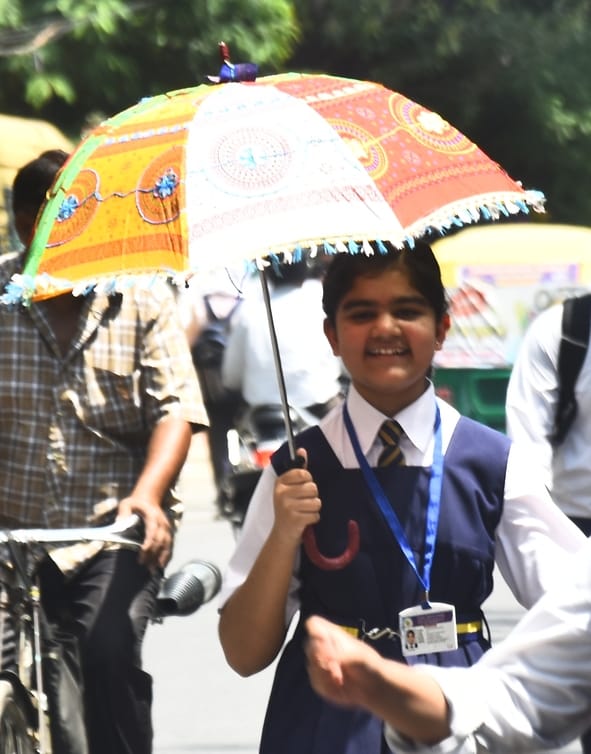 मंगलवार को धूप से बचाव करते लोग। 