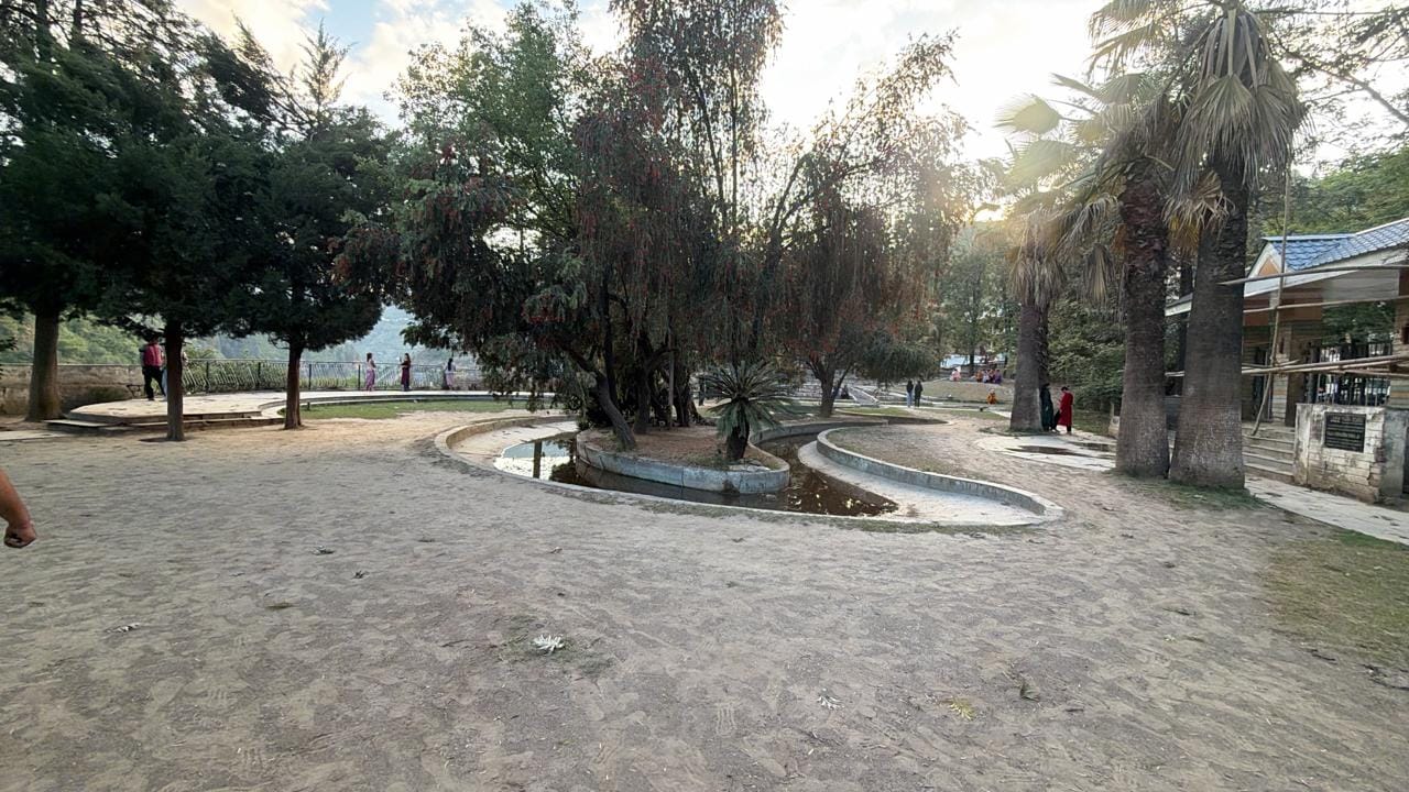 पार्क के अंदर दिन के समय बैठे लोग