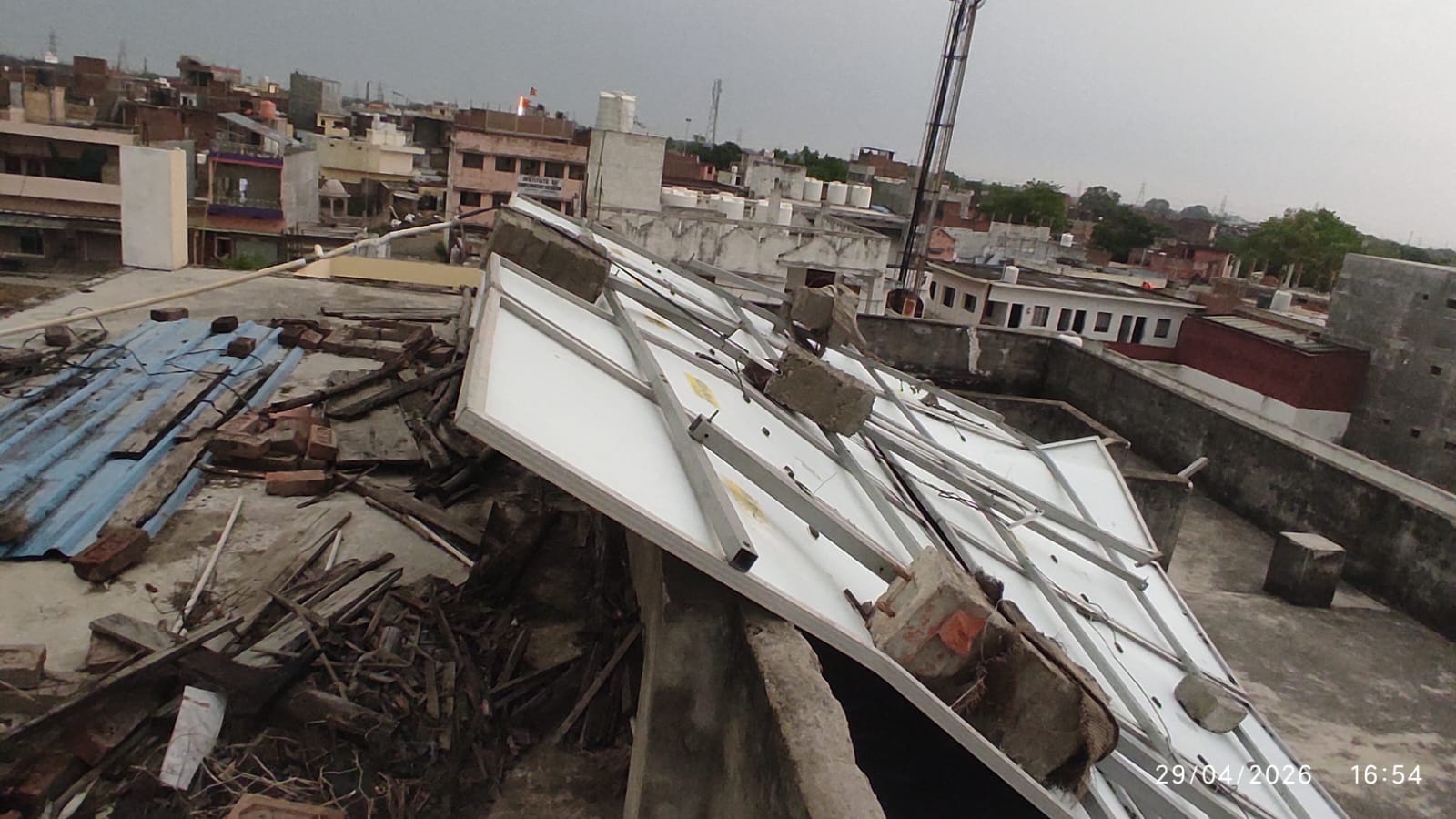 पड़री क्षेत्र में दाढ़ीराम में तेज आंधी के बीच सड़क पर गिरे टीन शेड उठाते ग्रामीण।-संवाद।