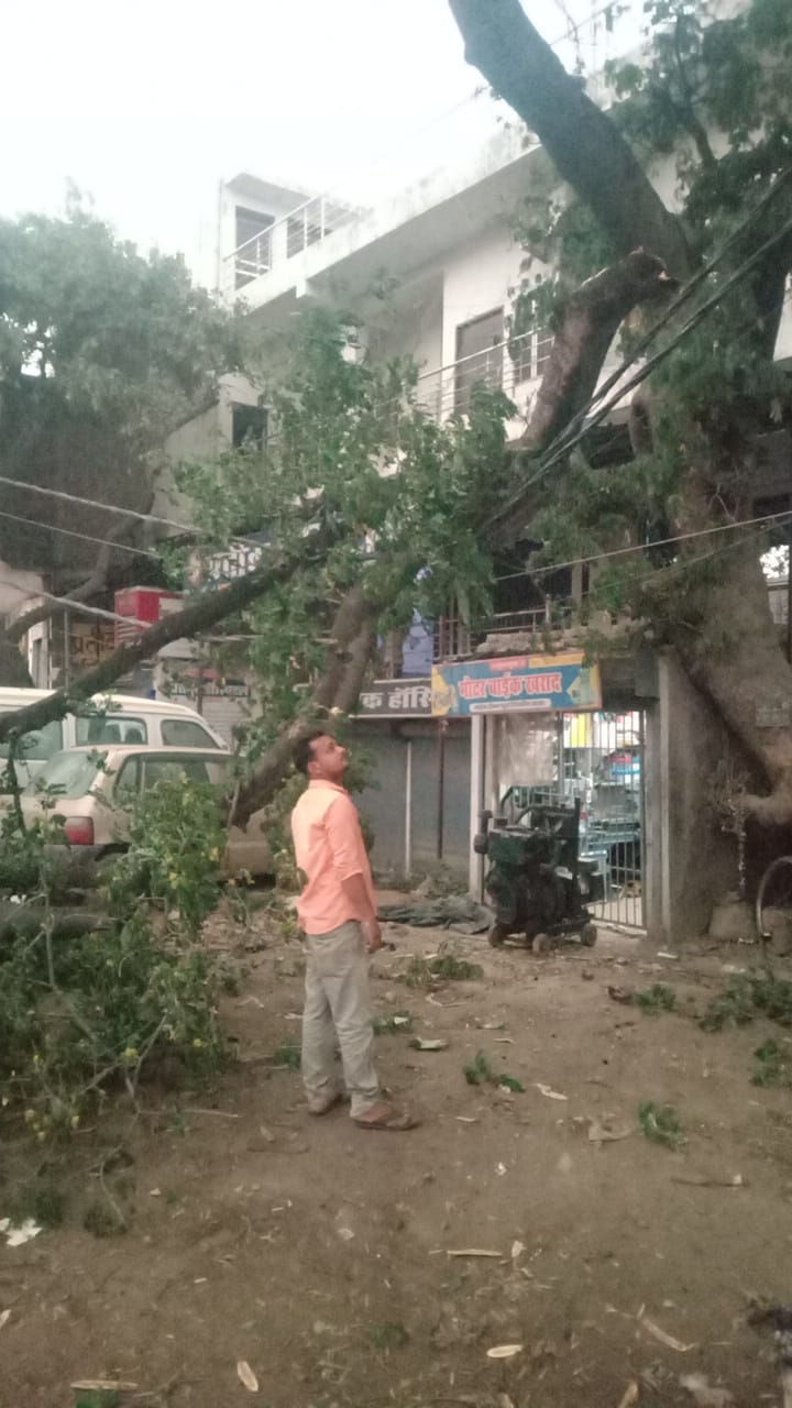 पड़री क्षेत्र में दाढ़ीराम में तेज आंधी के बीच सड़क पर गिरे टीन शेड उठाते ग्रामीण।-संवाद।