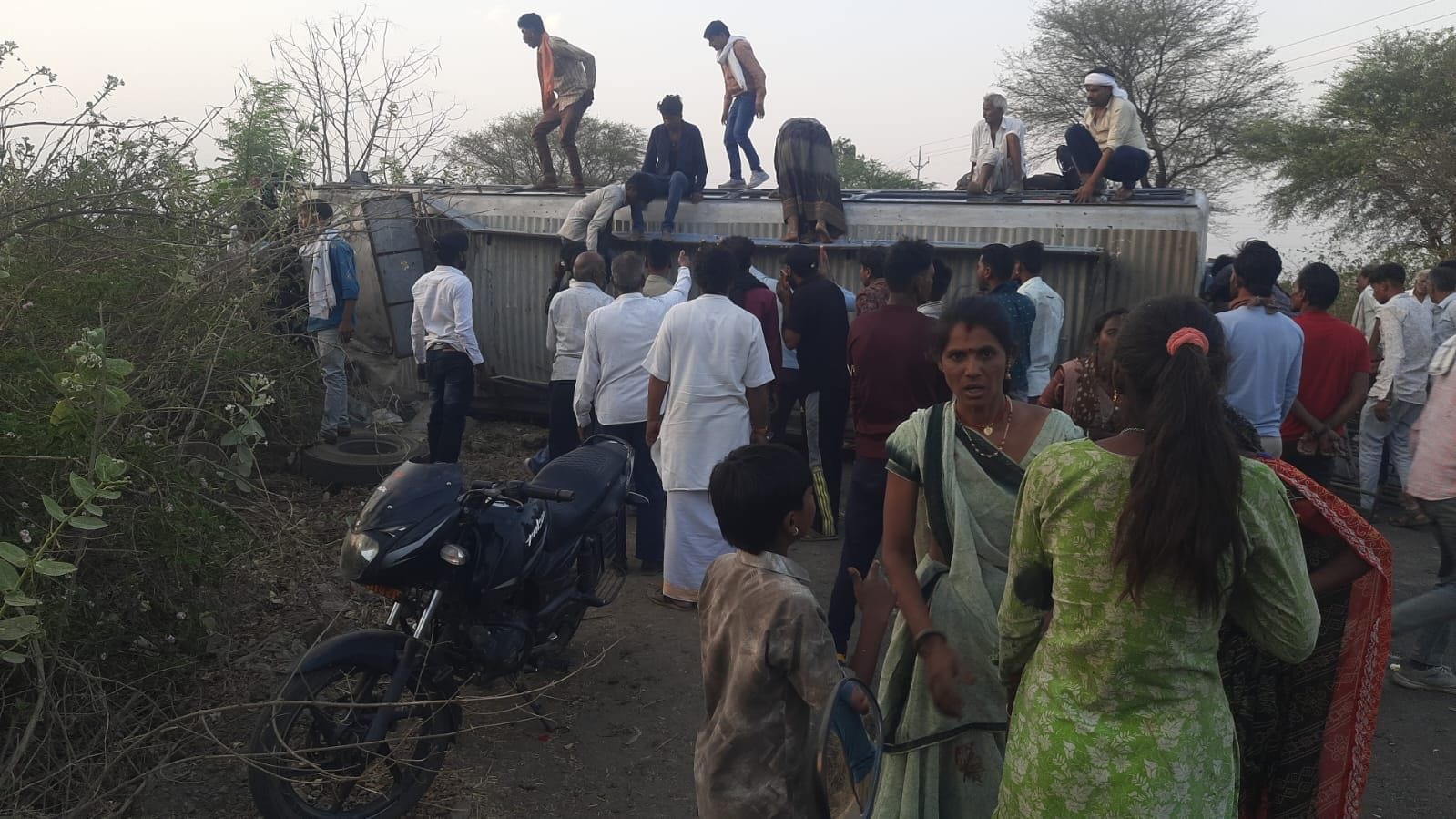 बस पलटने के बाद बस में फंसे यात्रियों को निकालते हुए 