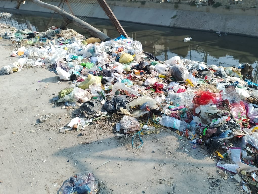 नगर निगम कार्यालय के बाहर धरने पर बैठे हड़ताली कर्मचारी। संवाद