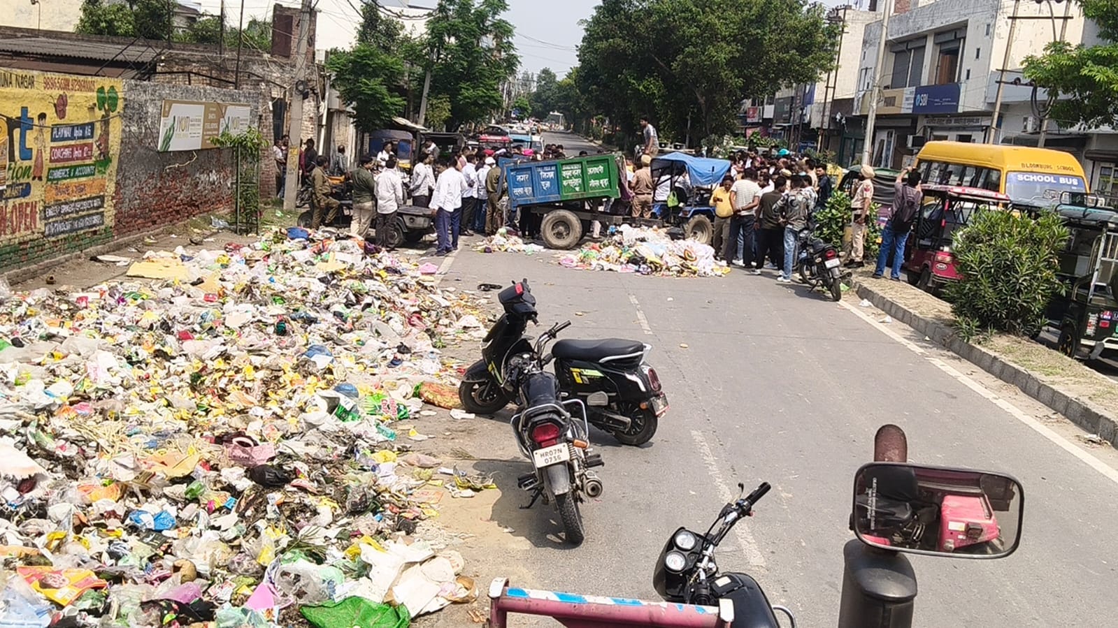 रेलवे रोड पर दुकान के बाहर से कचरे को साफ करता युवक। संवाद