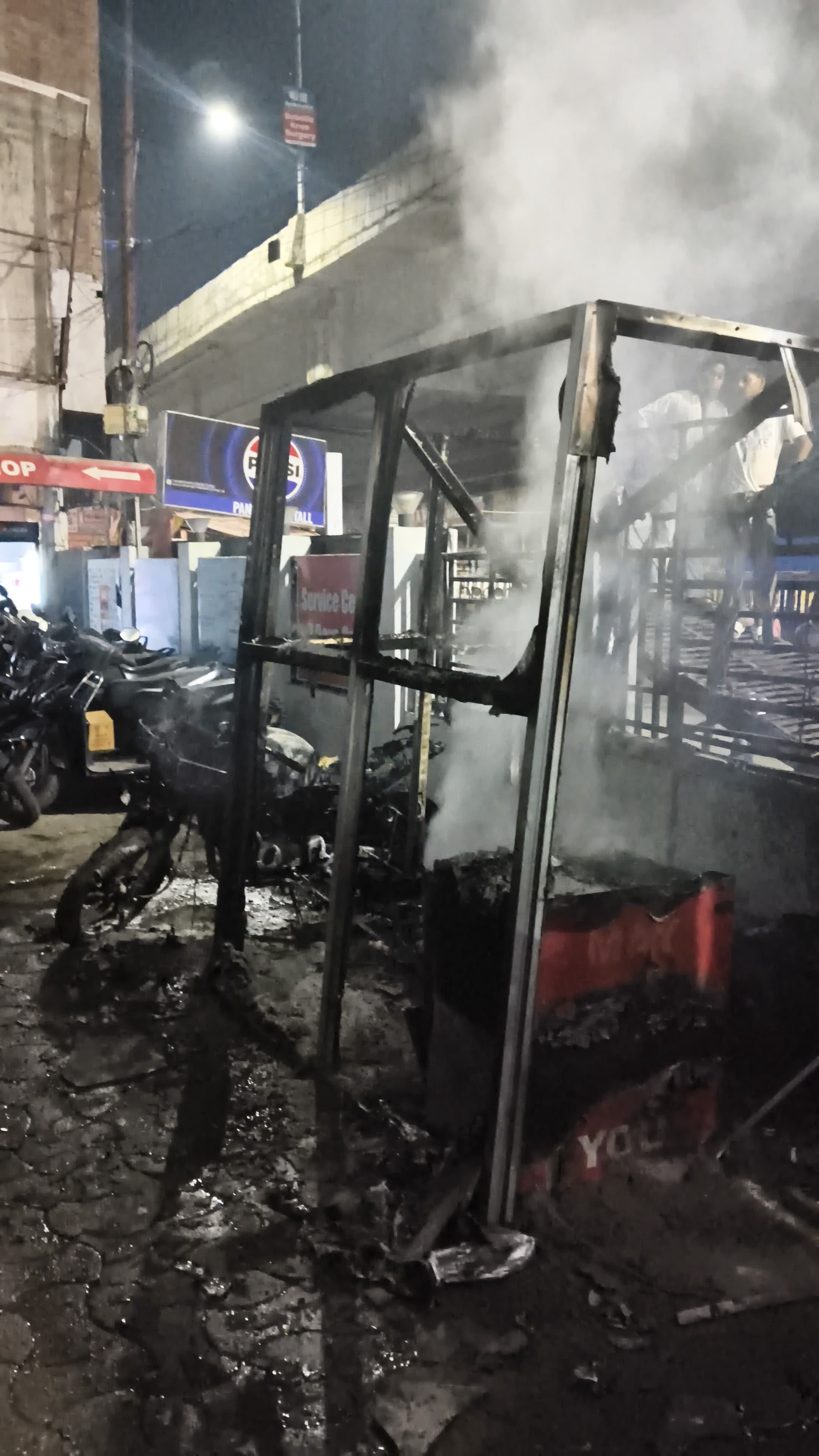 टेढ़ी पुलिया स्थित बाइक शोरूम के बाहरी हिस्से में लगी आग। 