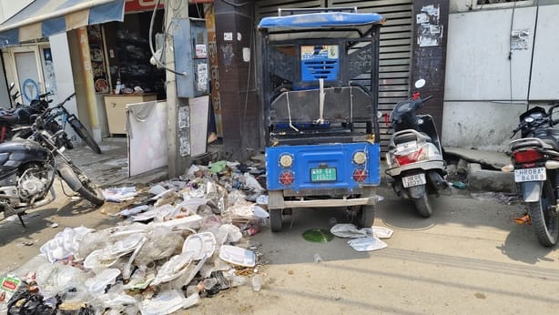 करनाल रोड पर लगे कचरे के ढेर के पास से मुंह ढक कर गुजरती छात्राएं। संवाद