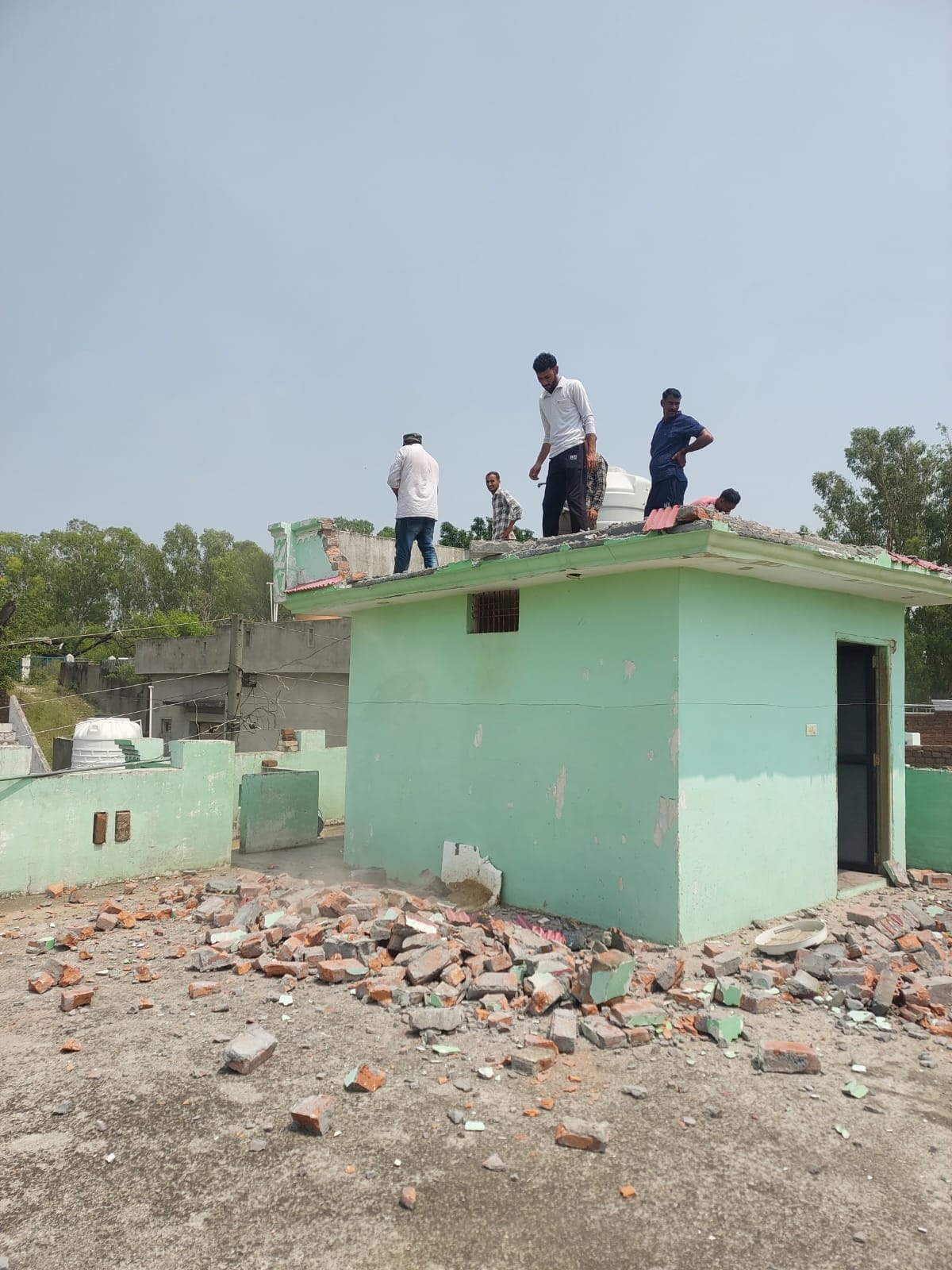 डमटाल क्षेत्र में एक आदतन नशा तस्कर की अवैध संपत्ति को तोड़ते प्रशासन की टीम। जागरूक पाठक