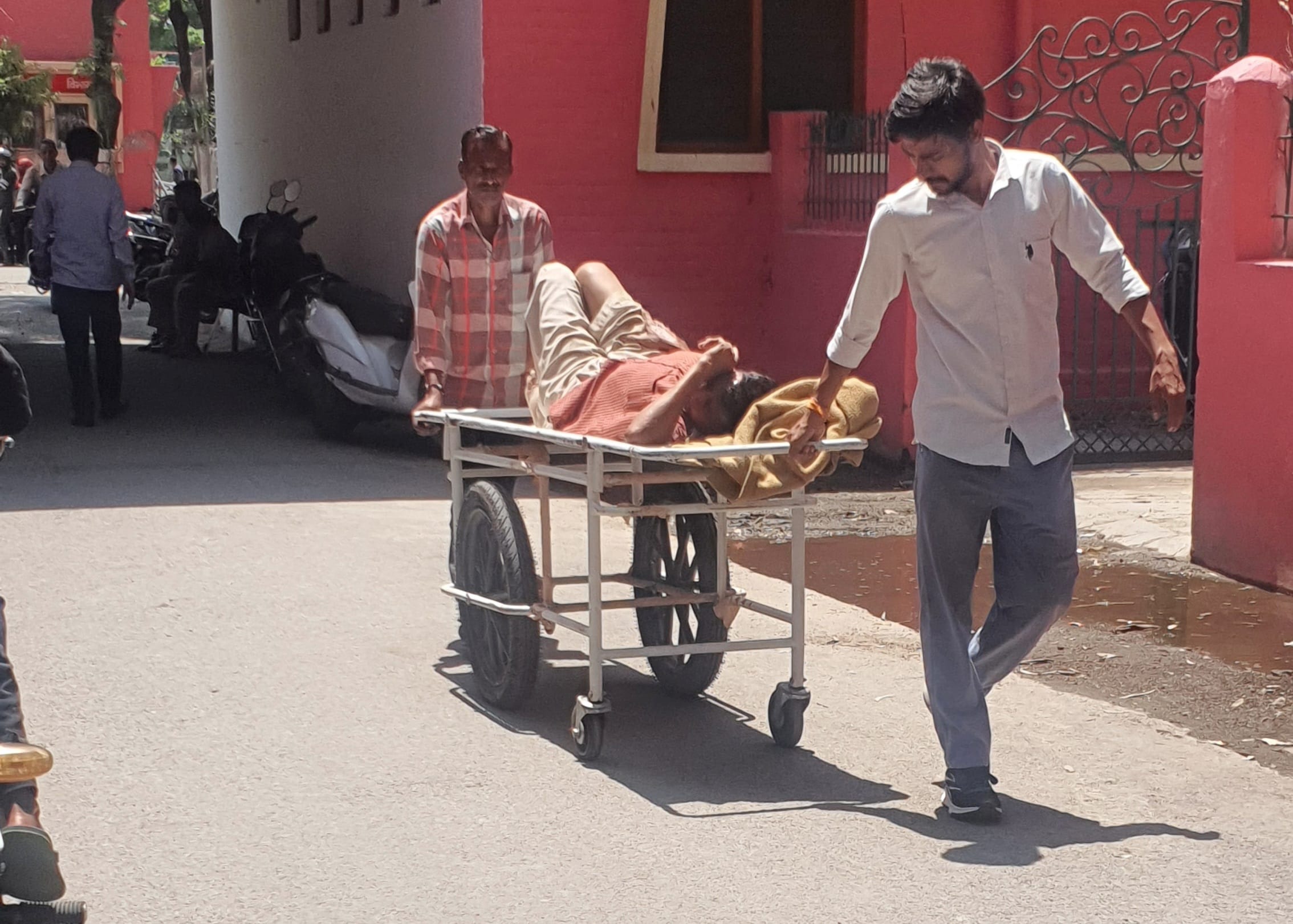 जिला अस्पताल में बिना वार्ड ब्वाय के व्हीलचेयर पर मरीज को वार्ड में ले जाते परिजन